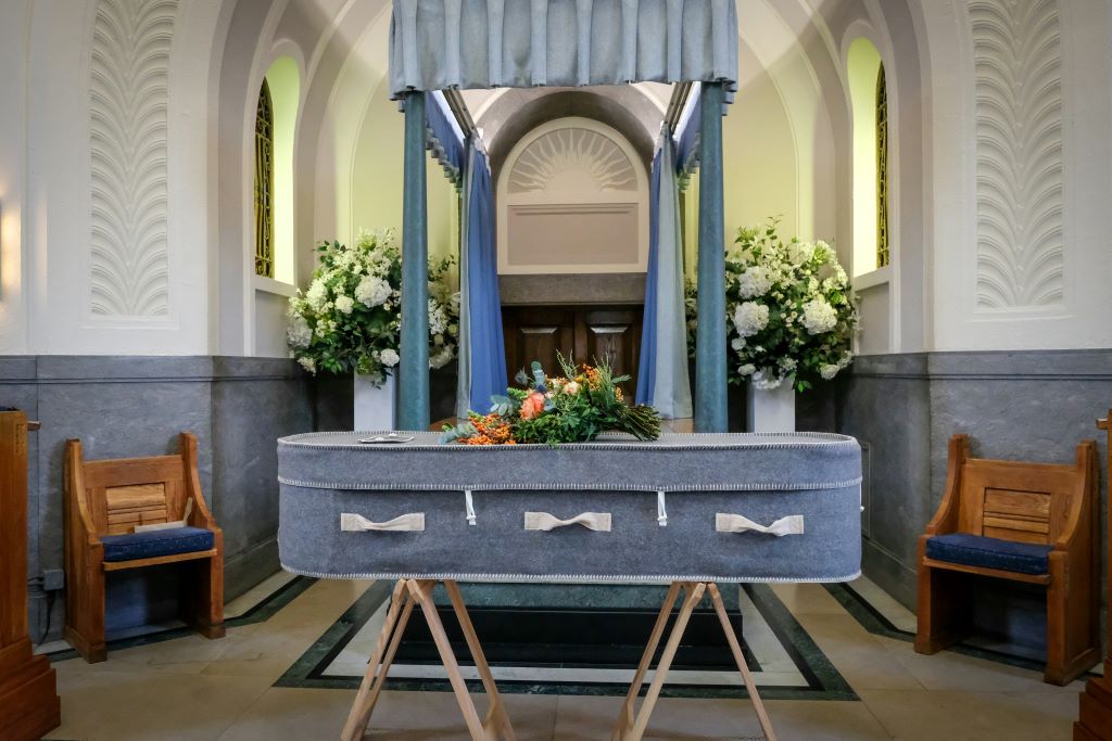 Wool-coffin-the-good-funeral-guide-GFxPZSLx5kk-unsplash Grey wool coffin at a funeral service